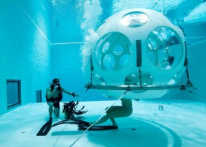 Belgians Florence Lutje Spelberg and Nicolas Mouchart dive into "The Pearl", a spheric dining room placed 5 metres underwater in the NEMO33 diving center, one of the world's deepest pools (33 metre/36 yards) built to train professional divers, before enjoying a meal inside, in Brussels, Belgium January 30, 2017. Picture taken January 30, 2017 REUTERS/Yves Herman